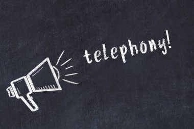 Hoparlörün tebeşir çizimi ve siyah masanın üzerine el yazısıyla yazılmış telefon.