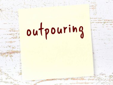 Tahta duvarda sarı yapışkan bir not ve el yazısıyla yazılmış bir yazı var.