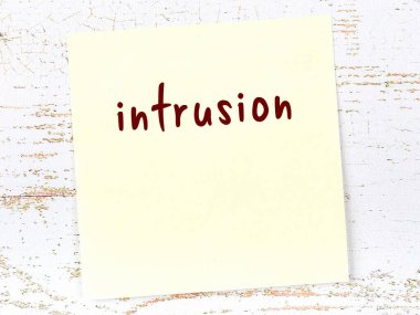 Davetsiz misafiri hatırlatma kavramı. Tahta duvarda üzerinde yazı olan sarı yapışkan kağıt.