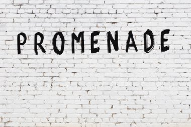 Üzerinde yazı olan beyaz tuğla duvar. Siyah boyayla yazılmış.