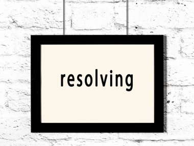 Siyah ahşap çerçeve beyaz tuğla duvarda asılı duran yazıt çözücü. 