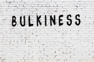 Beyaz tuğla duvara siyah boya ile yazılmış yazıtlar..