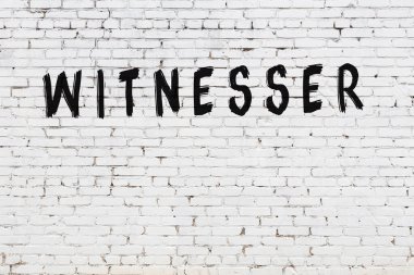 Üzerinde siyah boya bulunan beyaz tuğlalı bir duvar.