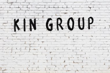 Yazıt grubu beyaz tuğla duvara siyah boya ile yazılmış..