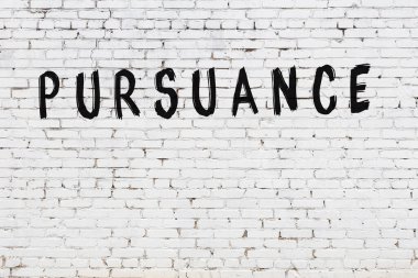 Üzerinde yazı olan beyaz tuğla duvar. Siyah boyayla yazılmış.