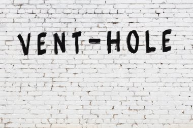 Üzerinde siyah boya bulunan beyaz tuğlalı bir duvar.