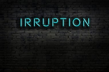 Duvarda yazı tahrişi olan neon levhası. Gece görünümü