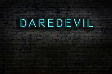 Tuğla duvara yazılı neon levhası. Gece görünümü