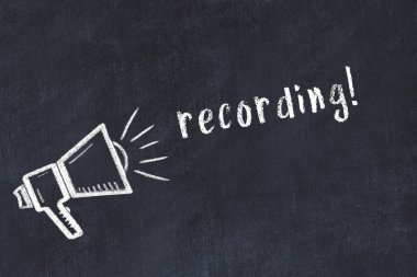 Hoparlörün tebeşir çizimi ve siyah masaya el yazısıyla yazılmış yazı kaydı