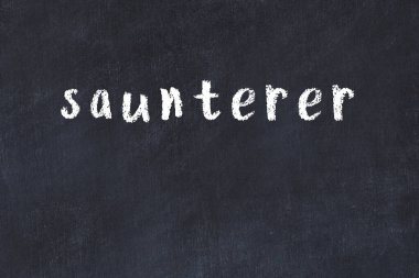 Tebeşir el yazısı yazması saunterci siyah masada.