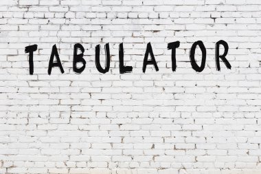 Beyaz tuğla duvara siyah boya ile yazılmış bir yazı çizelgesi..