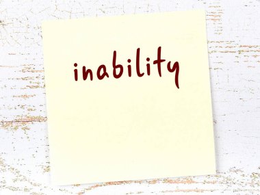 Tahta duvardaki sarı yapışkan notta elle yazılmış yazma yetersizliği var.