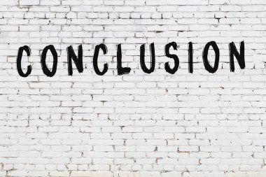 Üzerinde yazı olan beyaz tuğla duvar. Siyah boyayla yazılmış.