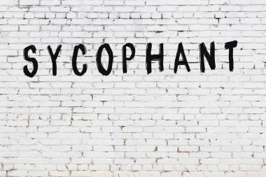 Yazılı beyaz tuğla duvar. Siyah boyalı el yazısı.