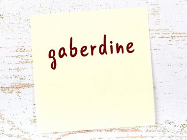 Ahşap duvarda el yazısı gaberdin olan sarı yapışkan bir not.
