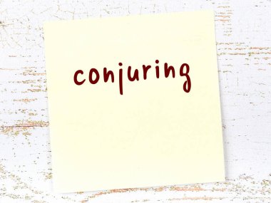 Sihirbazlık hakkında hatırlatma kavramı. Tahta duvarda üzerinde yazı olan sarı yapışkan kağıt.