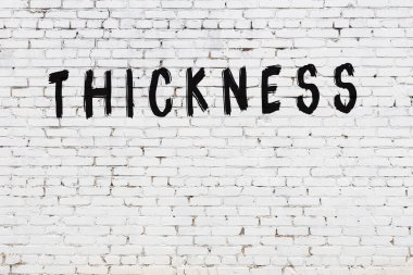 Yazı kalınlığı siyah boyayla yazılmış beyaz tuğla duvar.