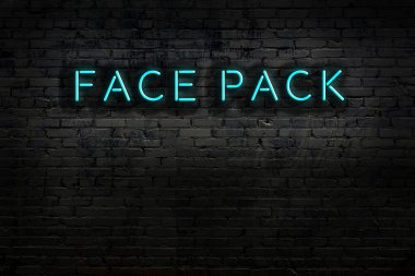 Duvara yazı yazılı neon levhası. Gece görünümü