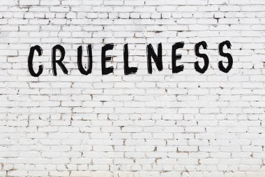 Yazılı beyaz tuğla duvar. Siyah boyayla yazılmış zalimlik.