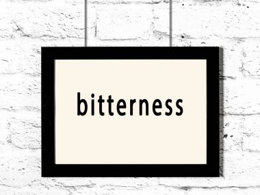 Siyah ahşap çerçeve beyaz tuğla duvarda asılıydı. 