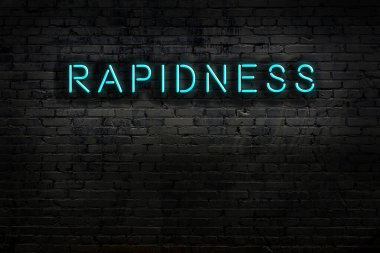 Tuğla duvara karşı hızlı yazılan neon tabela. Gece görünümü