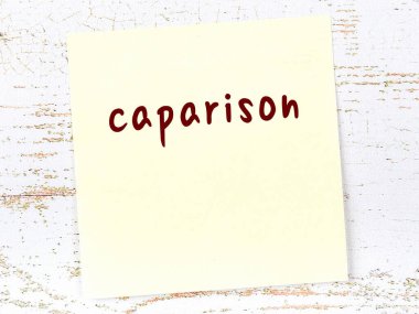 Tahta duvarda el yazısıyla yazılmış sarı yapışkan bir not var.