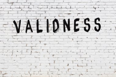 Yazı geçerliliği beyaz duvara siyah boya ile yazılmış..