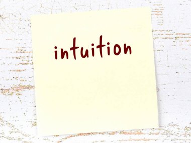 Sezgi hakkında hatırlatma kavramı. Tahta duvarda üzerinde yazı olan sarı yapışkan kağıt.