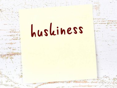 Ahşap duvarda el yazısıyla yazılmış kabarık sarı bir not var.