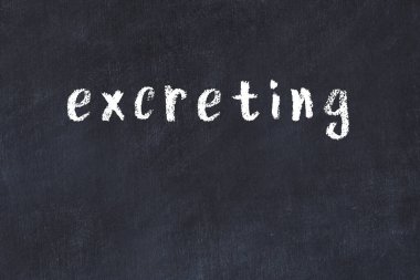 Tebeşir el yazısıyla yazılmış yazı siyah masaya dışkılanıyor