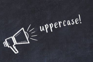 Hoparlörün tebeşir çizimi ve siyah masanın üzerine el yazısıyla yazılmış yazı büyük harf.