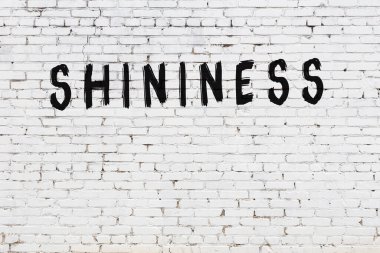 Siyah boyayla yazılmış beyaz tuğlalı bir duvar.