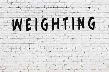 Yazı, beyaz tuğla duvara siyah boya ile yazılmış..