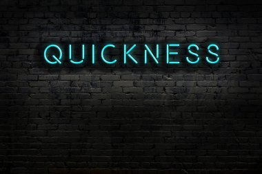 Tuğla duvara karşı hızlı yazılan neon tabela. Gece görünümü