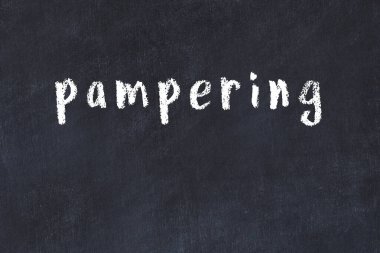 Tebeşir el yazısıyla yazılmış yazı siyah masada şımartılıyor.