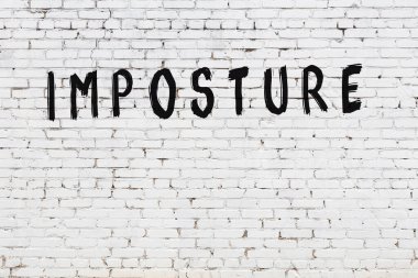 Siyah boyalı el yazısıyla yazması sahte bir yazı olan beyaz tuğla duvar.