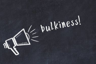 Hoparlörlerin tebeşir çizimi ve siyah masanın üzerine el yazısıyla yazılmış yazılar.