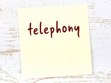 Telefonla ilgili hatırlatma kavramı. Tahta duvarda üzerinde yazı olan sarı yapışkan kağıt.