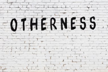 Üzerinde yazı olan beyaz tuğla duvar. Diğerlerinin el yazısı siyah boya.