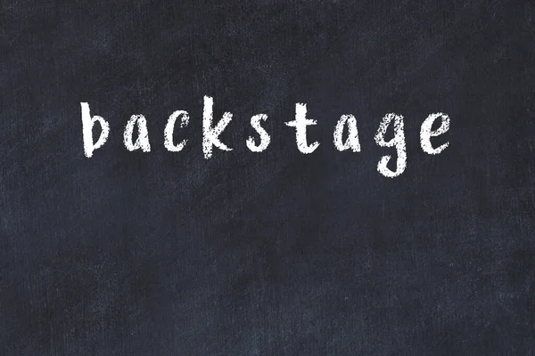 Sahne arkasında el yazısıyla yazılmış bir yazı tahtası var.