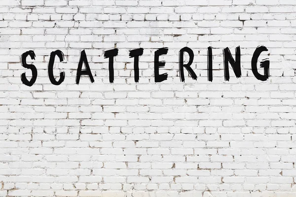 Üzerinde yazı olan beyaz tuğla duvar. Elle yazılmış siyah boya.