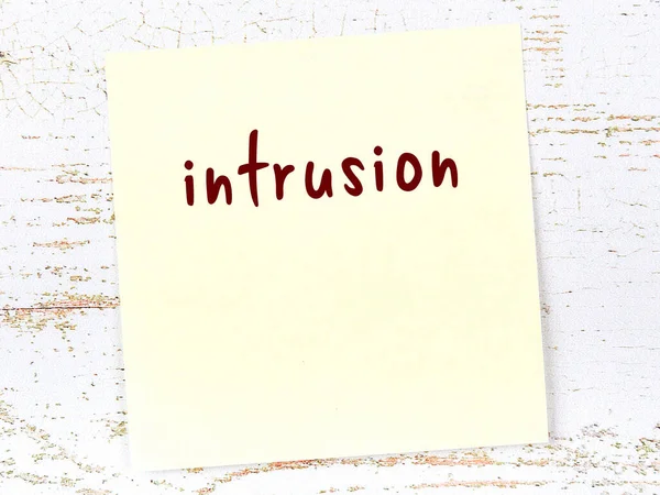 Davetsiz misafiri hatırlatma kavramı. Tahta duvarda üzerinde yazı olan sarı yapışkan kağıt.