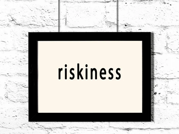 Black Wooden Frame Inscription Riskiness Hanging White Brick Wall — Stock Photo, Image