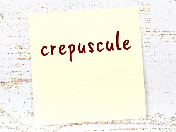 木制墙上的黄色粘贴字条 上面有手写的题词Crepuscule — 图库照片