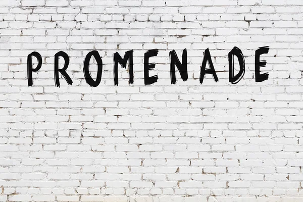 Üzerinde yazı olan beyaz tuğla duvar. Siyah boyayla yazılmış.