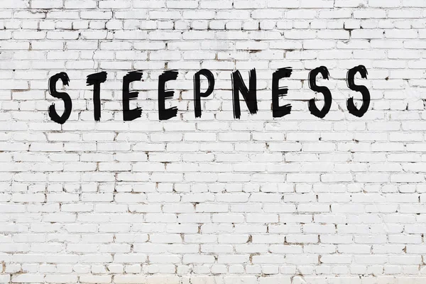 Siyah boyayla el yazısıyla yazılmış beyaz tuğla duvar.