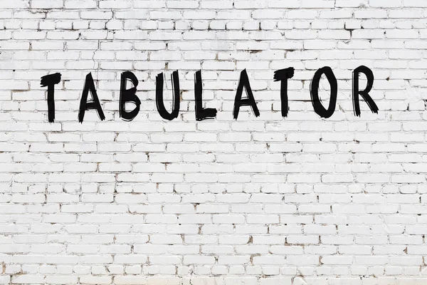 Beyaz tuğla duvara siyah boya ile yazılmış bir yazı çizelgesi..