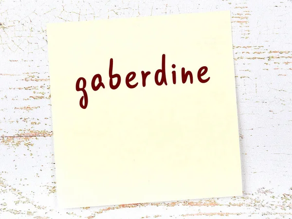 Ahşap duvarda el yazısı gaberdin olan sarı yapışkan bir not.