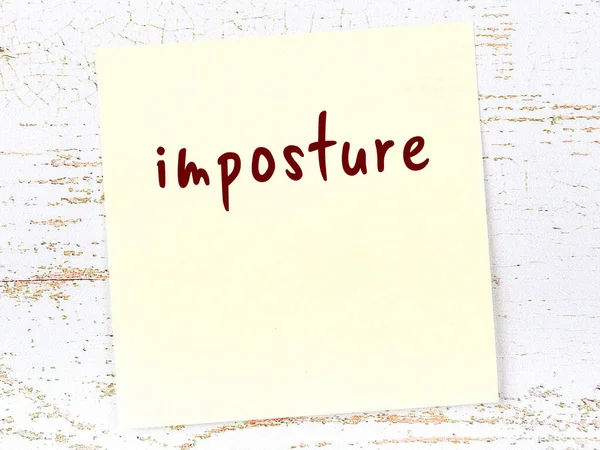 Sahtekarlık hakkında hatırlatma kavramı. Tahta duvarda üzerinde yazı olan sarı yapışkan kağıt.