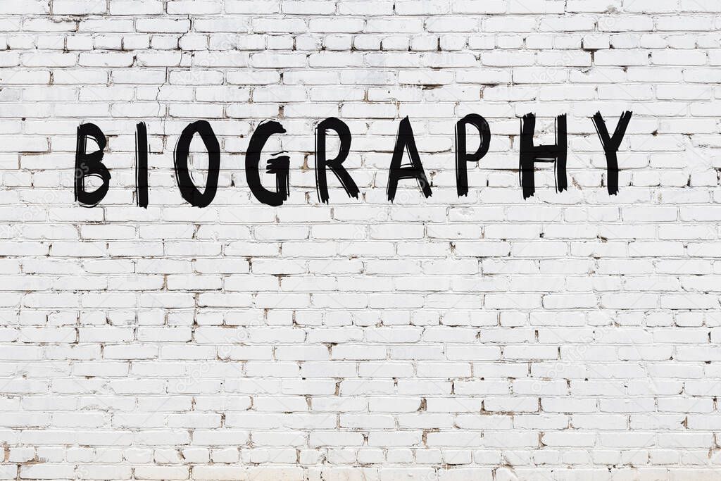 White brick wall with inscription biography handwritten with black paint